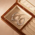 Detail view of bold polished stainless steel hoop earrings in a wooden jewelry box. - Irregular Teardrop Style (3#)