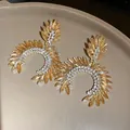 Detailed macro view of luxury marquise cut rhinestone earrings in warm golden tones. - Silver Earring Post Style / Gold Brown