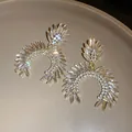Close-up of sparkling marquise rhinestone drop earrings with silver needle posts. - Silver Earring Post Style / Gold-Clear