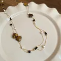 Detailed view of the vintage double-layer necklace featuring heart stones and pearls - Heart Stone Grain Double Beaded (65#) / Brown