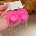Dettaglio di orecchini a cappello da cowboy rosa con nappe di strass brillanti su gancio - Stile Gancio / Rosa