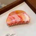 Vista detallada de una pinza para el cabello ovalada veteada naranja con curvas elegantes - 5# Pinza de pelo / Naranja