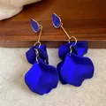 Close-up detail of elegant royal blue petal drop earrings featuring gold-tone metal accents - Blue