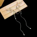 Close-up of silver phoenix brooch with elegant pearl tassels on dark background. - Silver