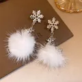 Dettaglio di orecchini a fiocco di neve e renna con pompon di pelliccia bianca - Argento