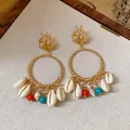 Dettaglio di orecchini a cerchio dorati boho con conchiglie naturali e ciondoli a perline. - Stile 21# Perno Argentato