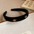 Close-up of black velvet headband with elegant golden bee metal ornaments. - Black