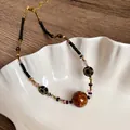 Collana vintage fatta a mano con perle marroni su vassoio a forma di conchiglia. - Texture Marmo (10#) / Marrone oro