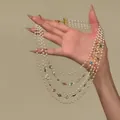 Detail of multi-layer pearl necklace with colorful gemstones in vintage style. - Gold