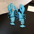 Detailansicht der blau lackierten Hummer-Ohrringe mit beweglichem Anhänger. - Hummerform / Blau