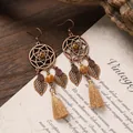 Close-up of bohemian dreamcatcher earrings with leaf charms and khaki tassels. - 32# Antique Gold