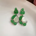 Primer plano detallado de pendientes de capullo en resina verde con perla blanca en gota - Par de Pendientes / Verde