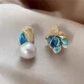 Macro detail of luxury asymmetric earrings featuring blue enamel and a large white pearl. - 31# Gold-Blue