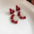 Detalle de pendientes vintage de resina roja con piedra blanca en forma de lágrima - Par de Pendientes / Rojo