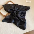 Primer plano de una pinza para el pelo de tela con lunares negros de estilo retro. - Lunar Negro