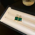 Close-up of vintage geometric earrings with green crystals and gold diamond-set studs - Silver Earring Post-Green