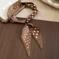 Close-up of brown paisley and polka dot silk scarf necklace with decorative ring fastener - Light Coffee Paisley