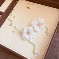 Detail view of stainless steel fabric flower jewelry set with green beads on leather tray - Gold Blue Green Beige