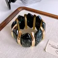 Dettaglio ravvicinato di un bracciale vintage in acrilico marmorizzato con elementi oro - Stile Giunzione in Metallo (77#) / Oro-Nero