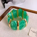 Dettaglio di un braccialetto vintage in acrilico marmorizzato verde con inserti oro - Stile Giunzione in Metallo (79#) / Oro-Verde