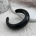 Detailed macro view of a glossy black resin open cuff bangle on a white minimalist background - Cuff Bracelet / Black