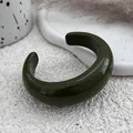 Detail view of a thick dark green resin open bangle showing its smooth glossy texture - Cuff Bracelet / Green