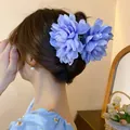 Close-up of a sweet light blue fabric flower hair claw clip elegantly worn in hair - Hair Claw (70) / Blue