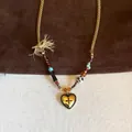 Detail view of vintage gold heart pendant necklace featuring colorful beads and gold chain - Necklace (7#) / Gold Brown