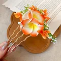 Detail showing the intricate plumeria flower and wavy golden prongs of the hair fork. - Plumeria Hairpin / Orange-White Gradient
