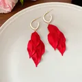 Elegant close-up of red matte petal drop earrings with gold hoop on white ceramic plate - Silver Earring Post Style / Red