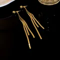 Eleganti orecchini lunghi a nappa d'oro con tripla catena a serpente su superficie nera - Stile Perno in Argento / Oro