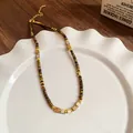 Close-up of a vintage stainless steel necklace with tiger eye beads and gold spacers. - Necklace (39#) / Gold Brown