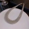Close-up detail of a minimalist silver spring-textured choker necklace on a plate. - Neck Ring - Silver / Large