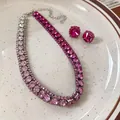 Primo piano di una collana girocollo con strass rosa e orecchini a bottone coordinati - Collana-Viola