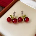 Detail view of elegant cherry stud earrings with red resin beads and zircon stones - Cherry Shape / Red