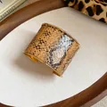 Detailaufnahme eines breiten, goldumrandeten Armreifs mit realistischem Schlangenmuster - Braunes Schlangenmuster Stil (HB4621) / Gold
