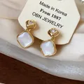Close-up of 18k gold-plated rhombus clip-on earrings with heart zircon details - Clip-on (Gold Plated) / One Pair / Gold