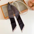 Primo piano dettagliato dell'elegante catena di perle e della trama del foulard di seta a righe. - Waist Chain 35-B&W Twill Pearl
