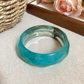 Detail view of a faceted acrylic bangle featuring an elegant blue marble swirl pattern - Faceted Bangle (HB3781) / Blue