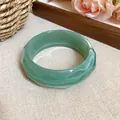 Detail view of a green marbled acrylic faceted bangle with a unique geometric design. - Faceted Bangle (HB3781) / Green