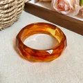 Close-up detail of a faceted amber acrylic bangle with elegant marbled pattern - Faceted Bangle (HB3781) / Dark Coffee