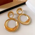 Detailed view of large golden textured double hoop earrings with a ribbed finish. - Steel Needle Style / Gold