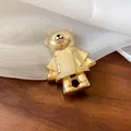 Gros plan d'une broche en forme d'ours doré avec des strass étincelants et texture. - Ours Doré