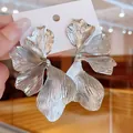 Detailed view of oversized silver petal earrings with textured metallic finish - Silver