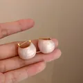 Dettaglio ravvicinato degli orecchini a cupola rosa perlato con elegante chiusura dorata - Orecchino N. 36 - Oro Rosa Fluente - A Forma Di Fagiolo (placcato Oro Vero)