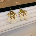 Detailansicht von Böhmischen Quastenohrringen mit Sonnenmotiv und cremefarbener Seide. - 21# Ohrhaken - Gold - Weiß