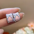 Detail close-up of pink enamel C-shaped hoop earrings featuring a silver bow design. - Bow C-Shape Style / Pink