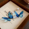 Close-up of elegant blue butterfly earrings with pearl accents and silver needles - Stud Style (HE20215-HE20216) / Silver-Blue