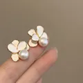 Close-up detail of elegant 18k gold plated flower stud earrings with central pearls - Silver Needle (Stud) / Gold-White