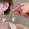 Close-up view of elegant holiday-style floral tassel earrings with imitation pearls on model - Style 18 Option 1